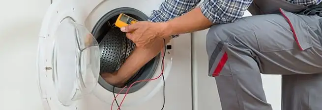 Dryer repair technician inspecting and repairing a clothes dryer in Columbia, SC