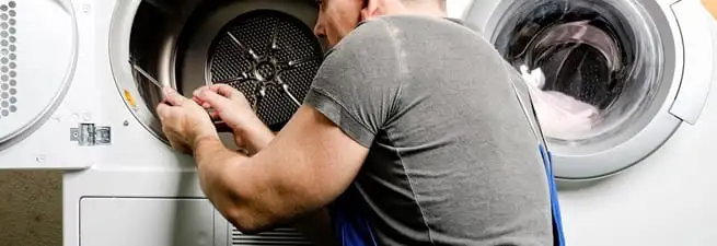 Dryer repair technician fixing a clothes dryer drum in Columbia, SC