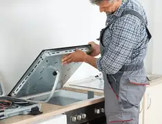 Appliance repair technician installing a built-in cooktop in Columbia, SC