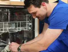 Dishwasher repair technician inspecting and servicing an open dishwasher in Columbia, SC