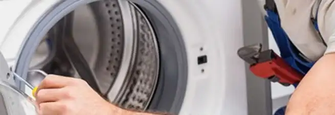 Appliance technician repairing a clothes dryer drum and internal parts in Columbia, SC