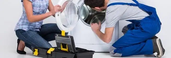 Washer repair technician inspecting a front-load washing machine with tools in Columbia, SC
