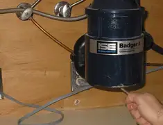 Garbage disposal repair technician tightening the mounting ring under a sink in Columbia, SC
