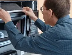 Appliance repair technician replacing a microwave vent filter in Columbia, SC