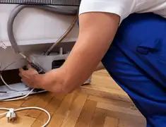 Appliance repair technician fixing refrigerator water line and connections in Columbia, SC