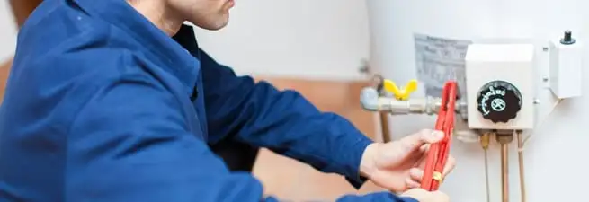 Water heater repair technician adjusting the temperature control and gas valve in Columbia, SC